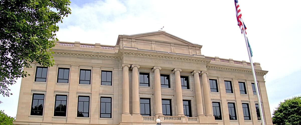 A large, classical building with columns and a flagpole.