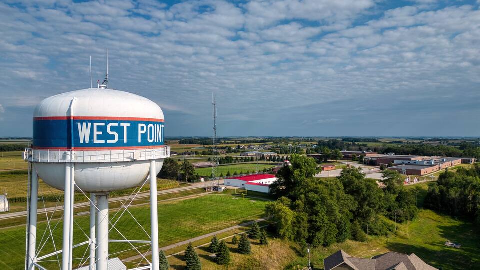 A water tower labeled "WEST POINT" with a rural landscape in the background.