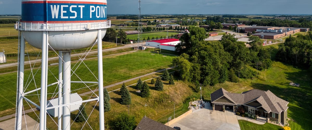 A water tower labeled "WEST POINT" with a rural landscape in the background.
