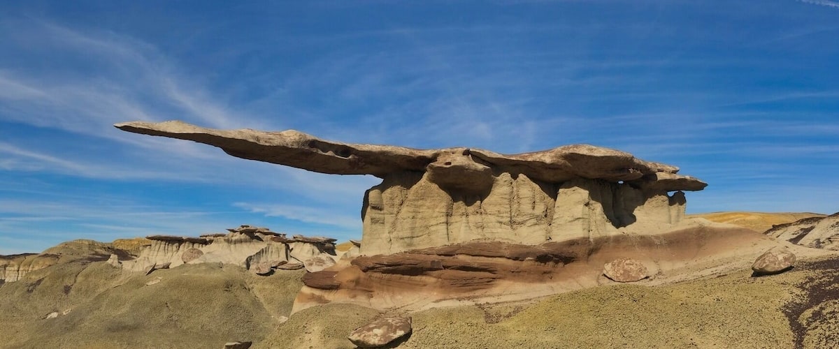 After a few miss steps and some entertaining driving down some very old dirt roads. Probably the biggest HooDoo in New Mexico hides on a south facing slope in the Bisti De Na Zin Wilderness in the north end of the State. The overhang is more than 12'-0" composed of very thin fragile rock. Somewhere between 2.5 and 3 million years old rocks are the basis for this incredible spectacle.
The whole area is packed with many formations of all shapes and sizes. The access and location are deliberately vague as to avoid over use of this amazing landmark. If there is any chance of rain in the forecast avoid at all costs as the roads will become impassable.