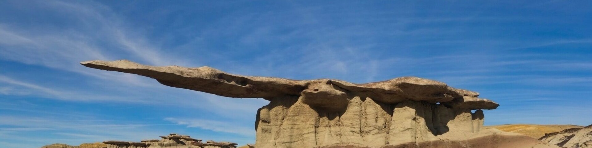 After a few miss steps and some entertaining driving down some very old dirt roads. Probably the biggest HooDoo in New Mexico hides on a south facing slope in the Bisti De Na Zin Wilderness in the north end of the State. The overhang is more than 12'-0" composed of very thin fragile rock. Somewhere between 2.5 and 3 million years old rocks are the basis for this incredible spectacle.
The whole area is packed with many formations of all shapes and sizes. The access and location are deliberately vague as to avoid over use of this amazing landmark. If there is any chance of rain in the forecast avoid at all costs as the roads will become impassable.