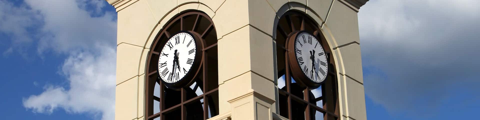 Modern clock tower structure against blue sky