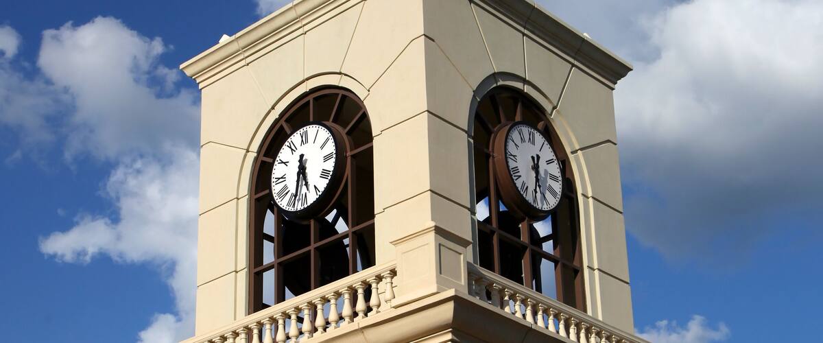 Modern clock tower structure against blue sky