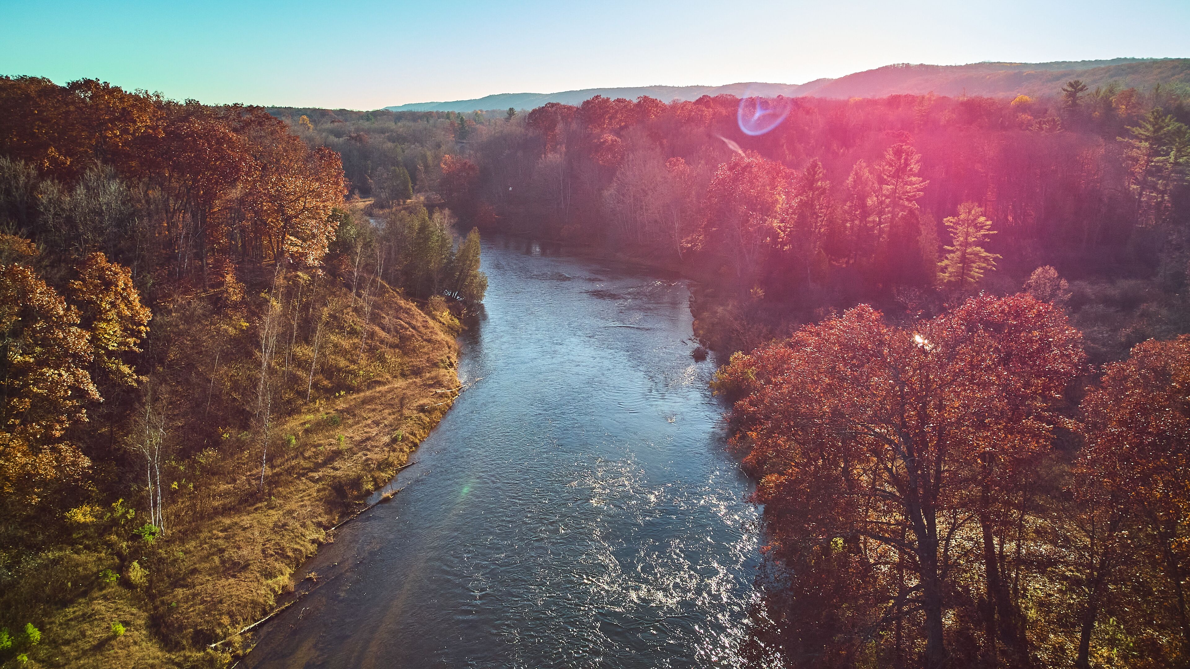Aerial solar flare over Michigan river during late fall with warm colors