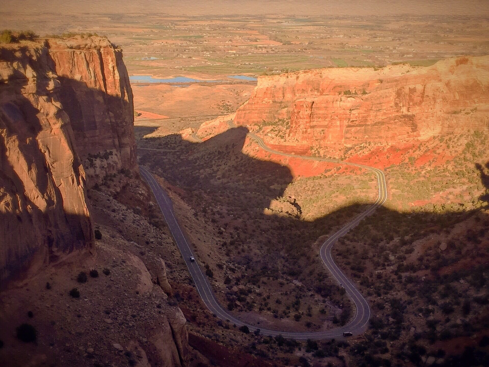 Fruita Canyon Overlook is a lofty roadside viewpoint at the head of four-mile-long Fruita Canyon on the west side of Colorado National Monument. The fenced overlook is reached by a 90-foot hike on a gravel path from a small parking area on Rim Rock Drive that’s 0.4 miles west of the park visitor center. Fruita Canyon, which begins near the monument’s west entrance station, is a steep canyon lined with towering Wingate sandstone walls. Rim Rock Drive snakes up the canyon below before climbing its west side. The canyon floor is composed of 1.5-billion-year-old rock that is the remains of an ancient mountain range. The broad Grand Valley, carved by the Colorado River, opens beyond Fruita Canyon. The northern horizon is an escarpment of the dark Book Cliffs topped with the lighter-colored Roan Cliffs. Note Balanced Rock, a precarious pinnacle by the right canyon wall, above the road below the overlook. #monumentvalley #viewcolorado #colorado #exploring #mykindoffun #mykindofday