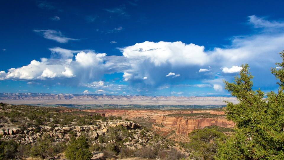A mountainous landscape with a clear sky and scattered clouds.