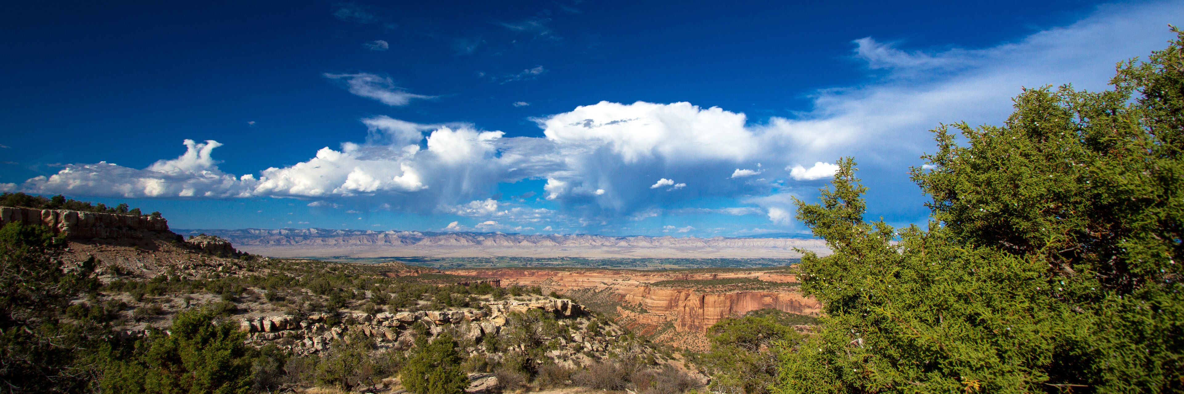A mountainous landscape with a clear sky and scattered clouds.