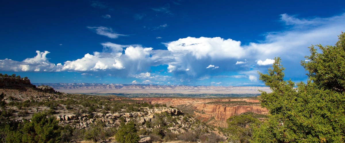A mountainous landscape with a clear sky and scattered clouds.