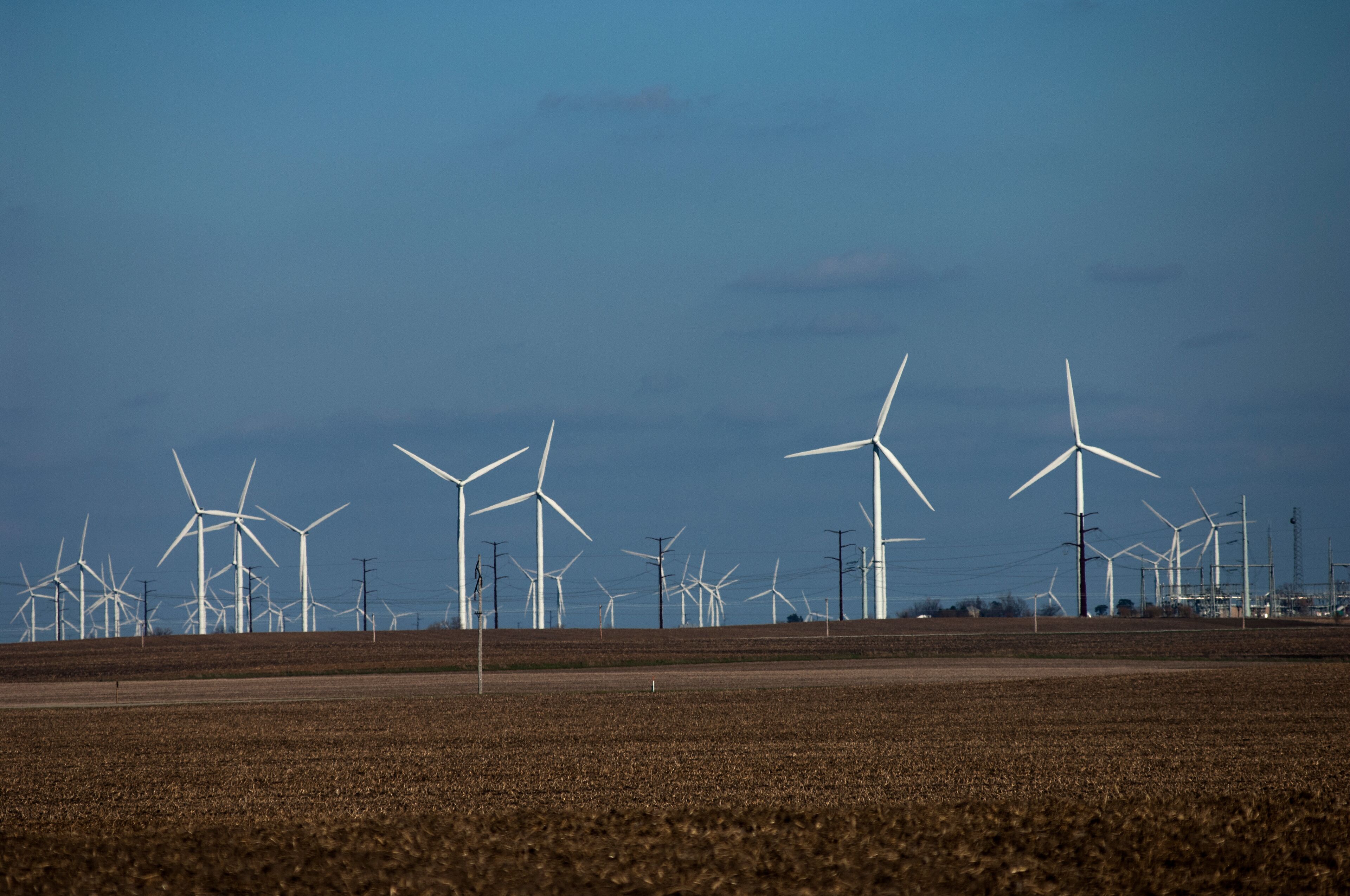 A wind farm with multiple wind turbines in a field.