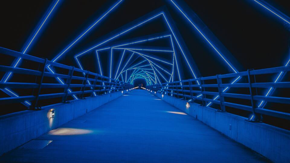 A bridge with blue neon lights forming a geometric pattern.