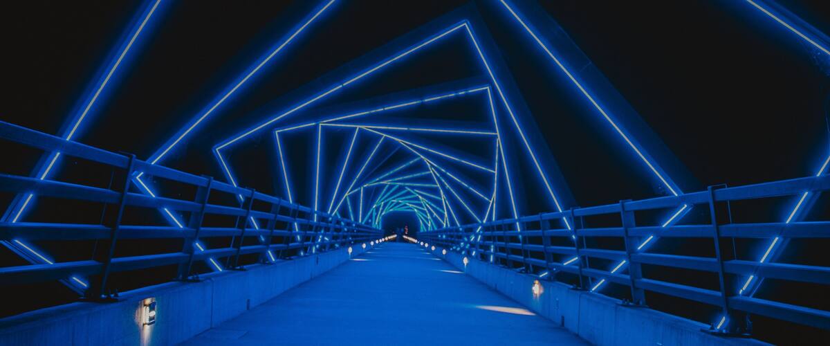 A bridge with blue neon lights forming a geometric pattern.