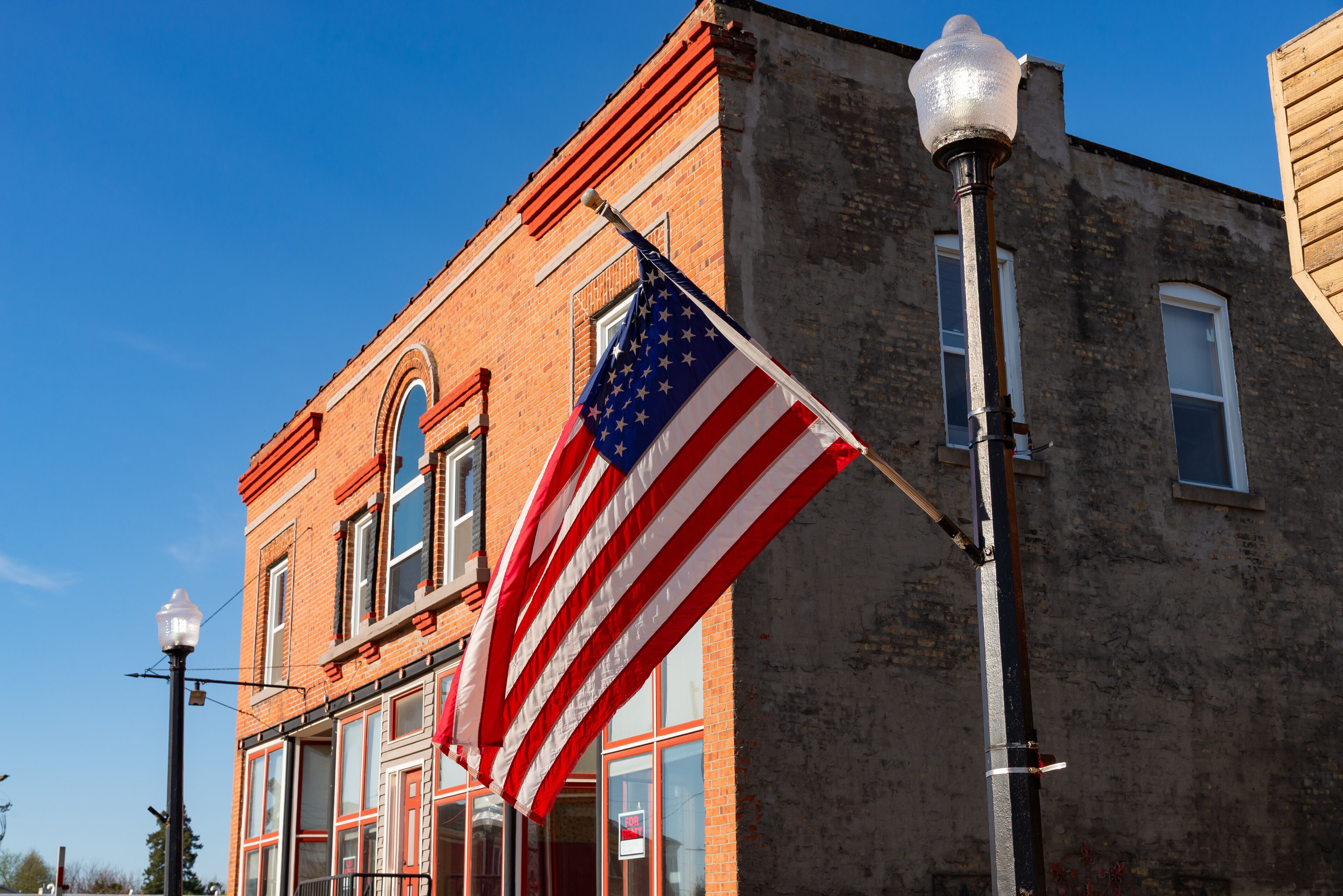 A brick building with a flagpole displaying the American flag.