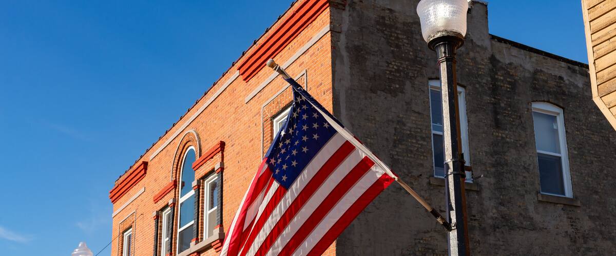 A brick building with a flagpole displaying the American flag.