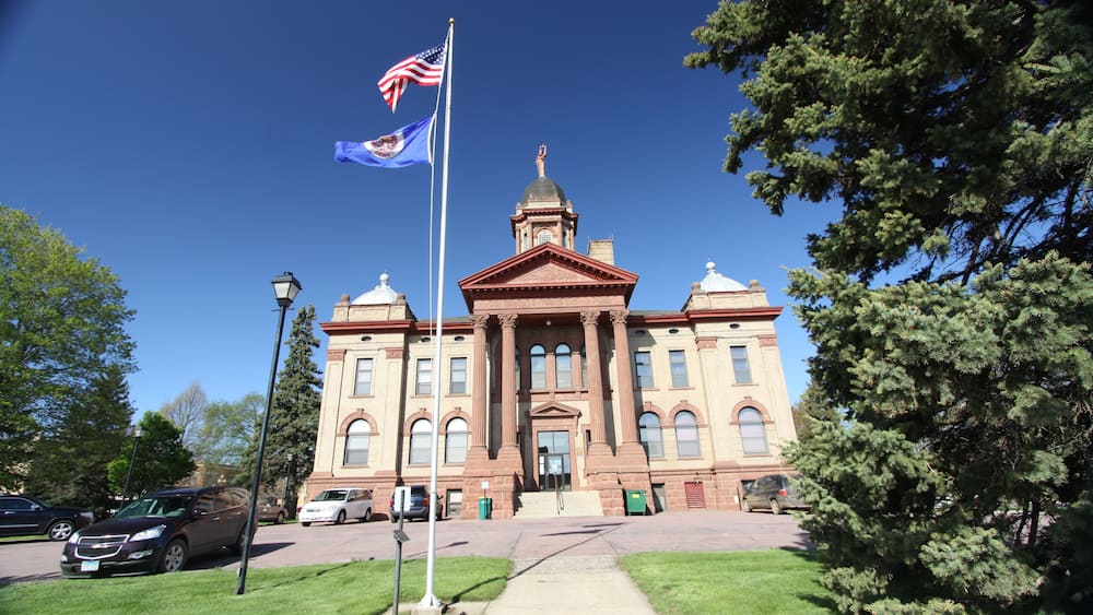 A large, historic building with a prominent dome and flagpole.