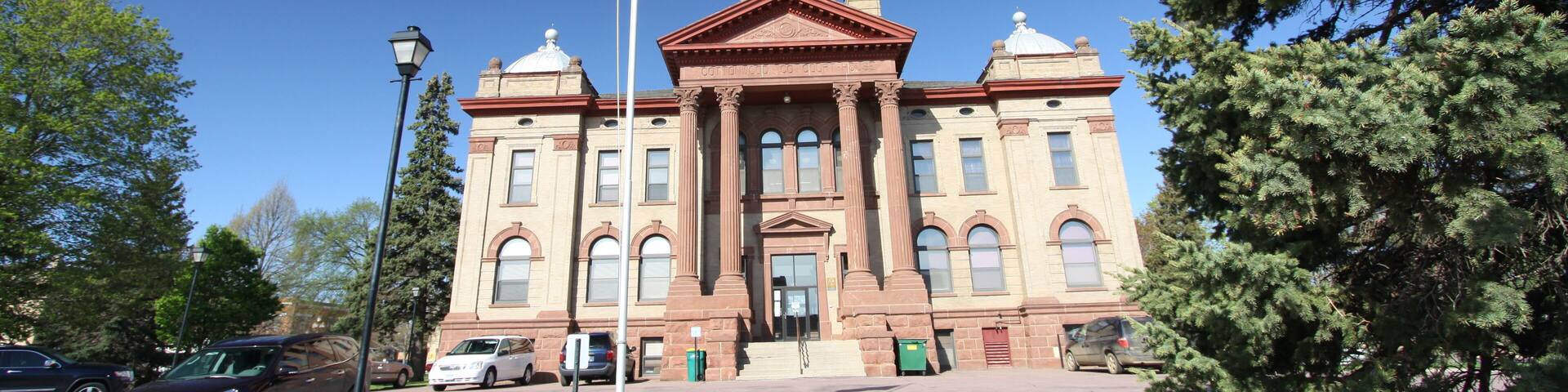 A large, historic building with a prominent dome and flagpole.