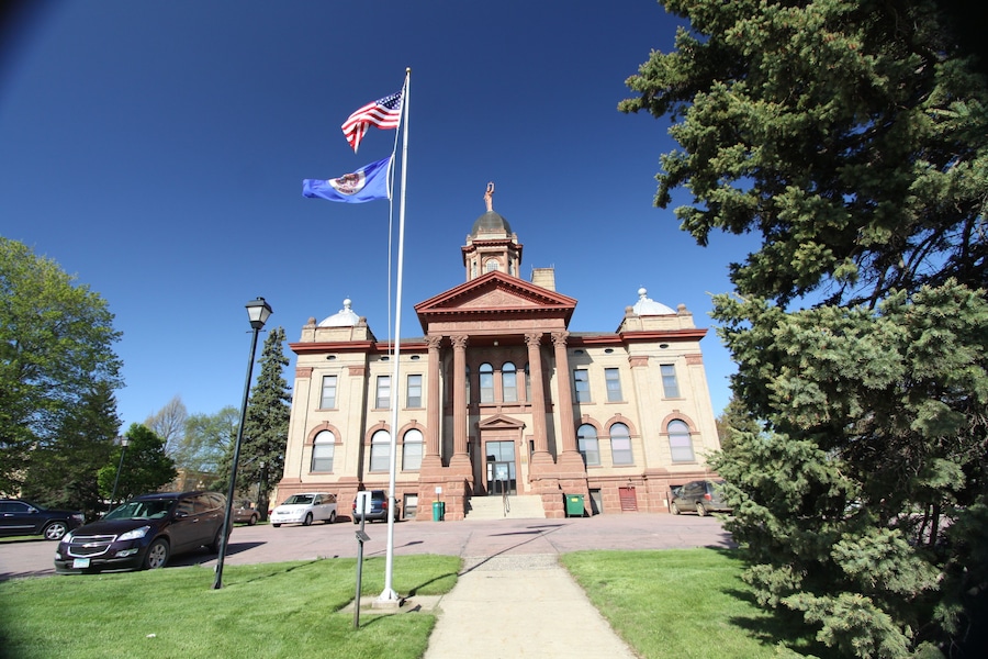 A large, historic building with a prominent dome and flagpole.