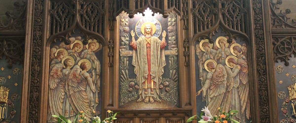 A religious iconostasis with intricate carvings and floral arrangements.