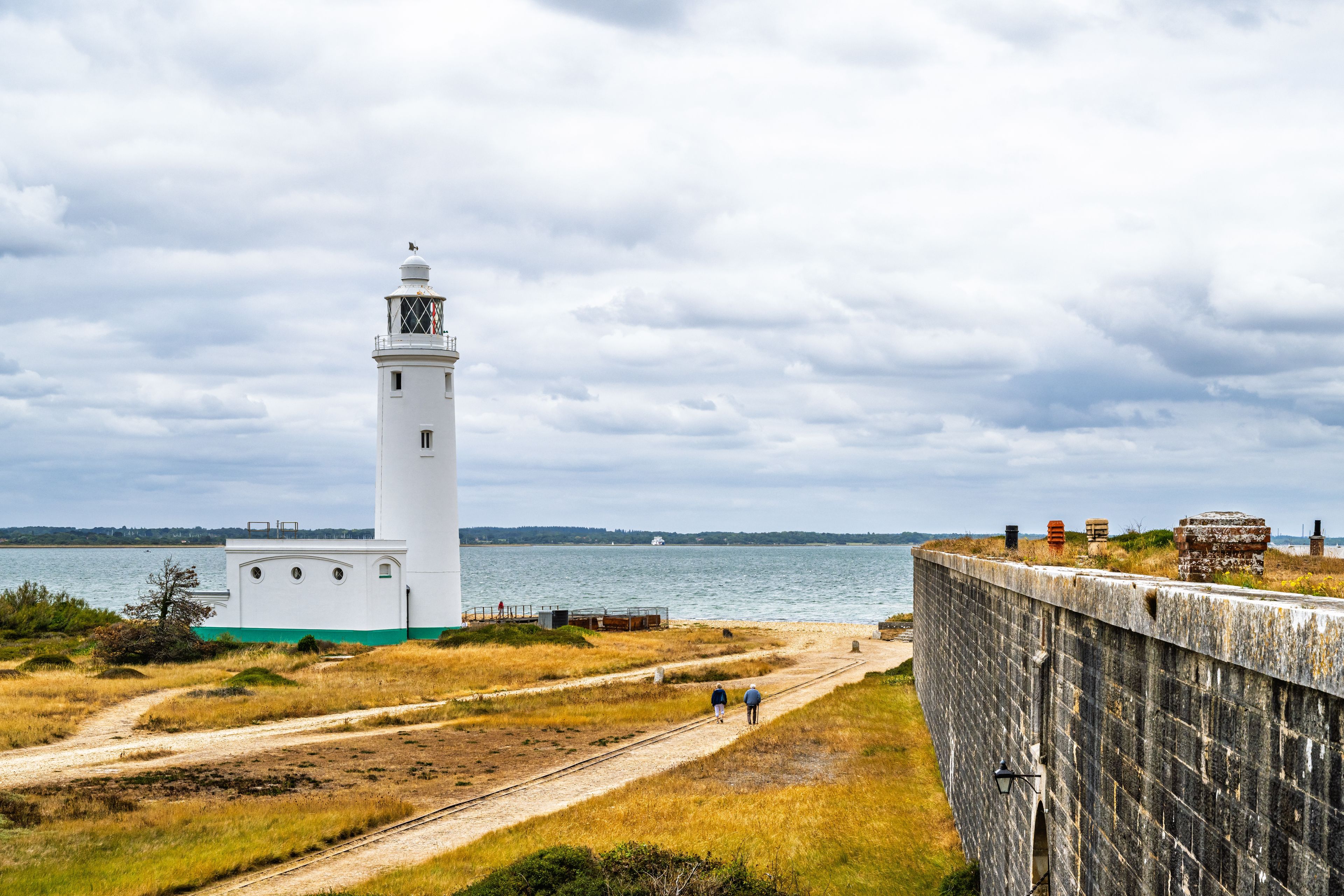 A lighthouse, a body of water, and a railway track.
