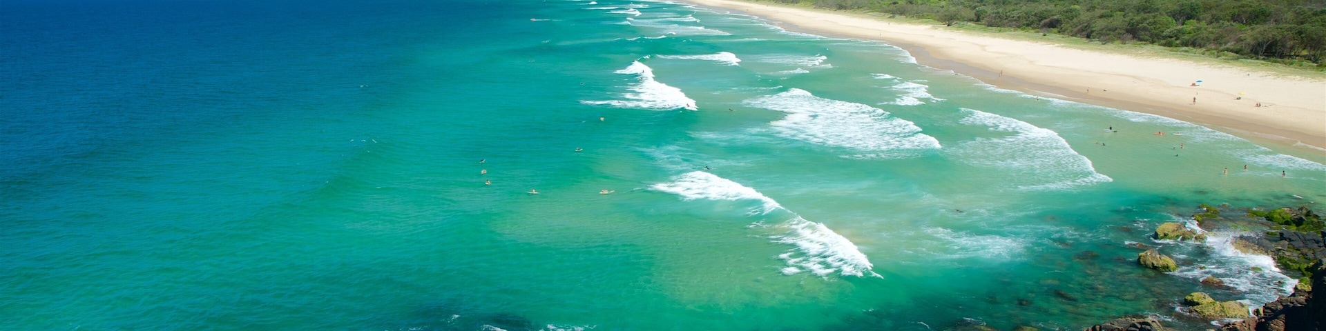 Cabarita Beach ofreciendo costa rocosa, una playa de arena y olas