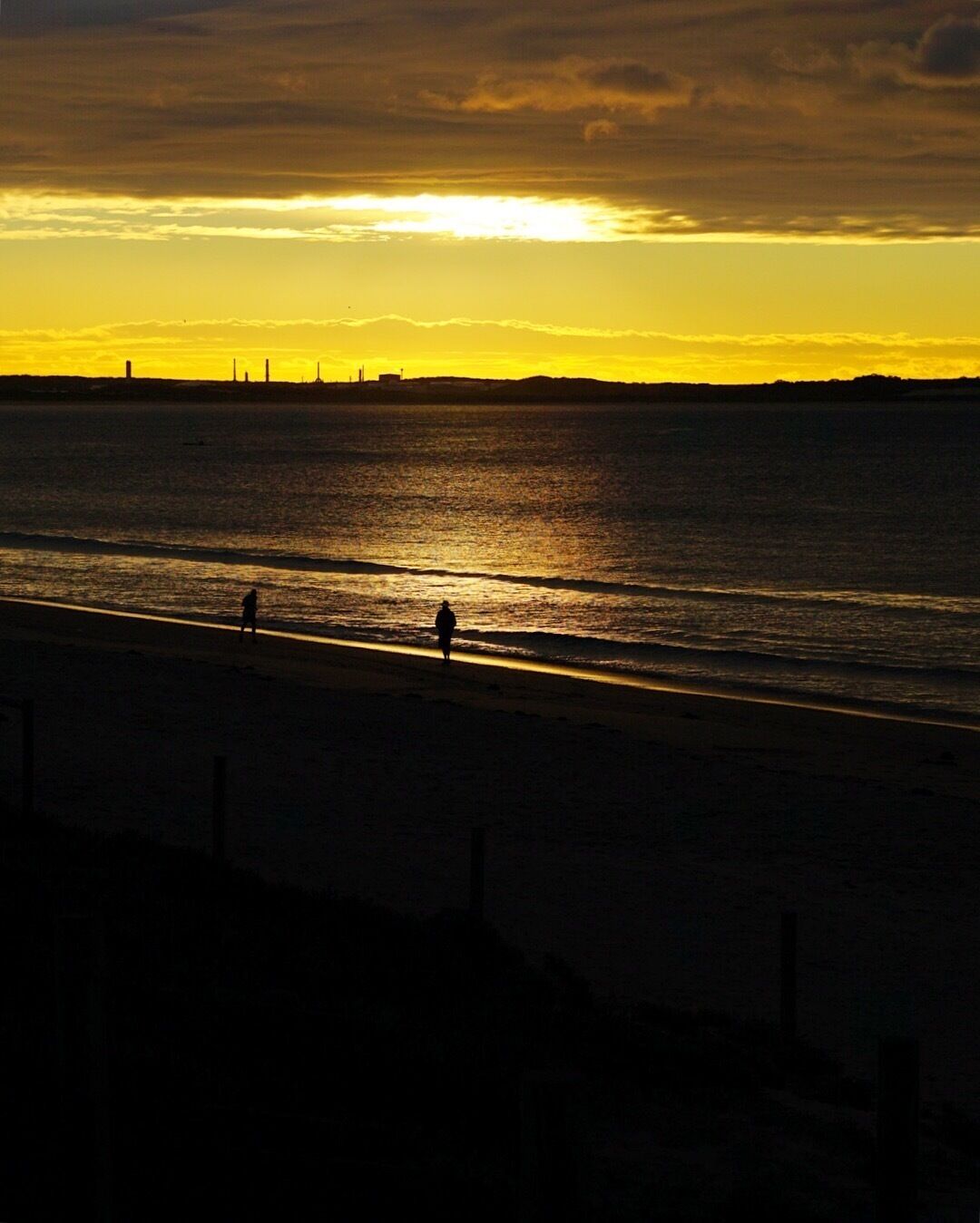 Shot at dawn of people taking their daily walk along the beach. In the distance is the now defunct petrochemical plant now in use a petrol storage facility. 

This is a great part of the world worthy of inclusion in any Sydney itinerary.
