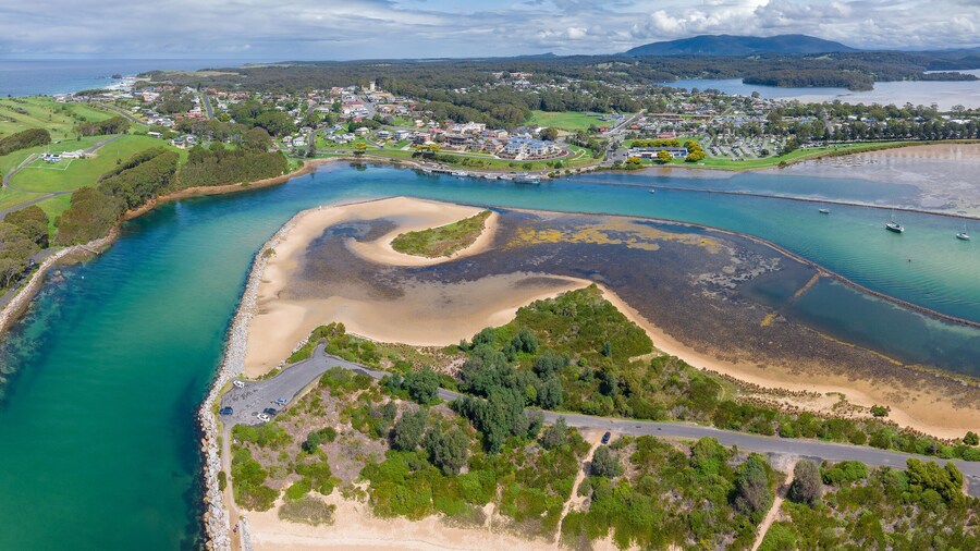 Aerial panorama of a winding river system flowing past a coastal township