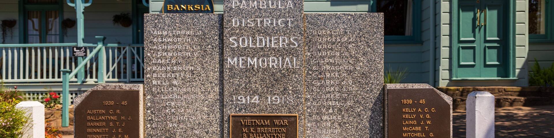 A memorial with names of soldiers from the 1914-1918 and 1939-45 wars, located in front of a building with a green door.