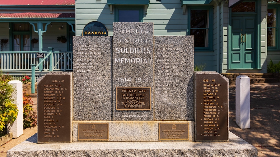 A memorial with names of soldiers from the 1914-1918 and 1939-45 wars, located in front of a building with a green door.