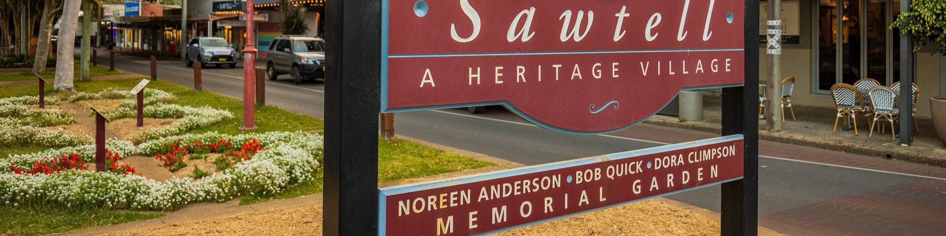 A sign for Sawtell Heritage Village with a memorial garden.