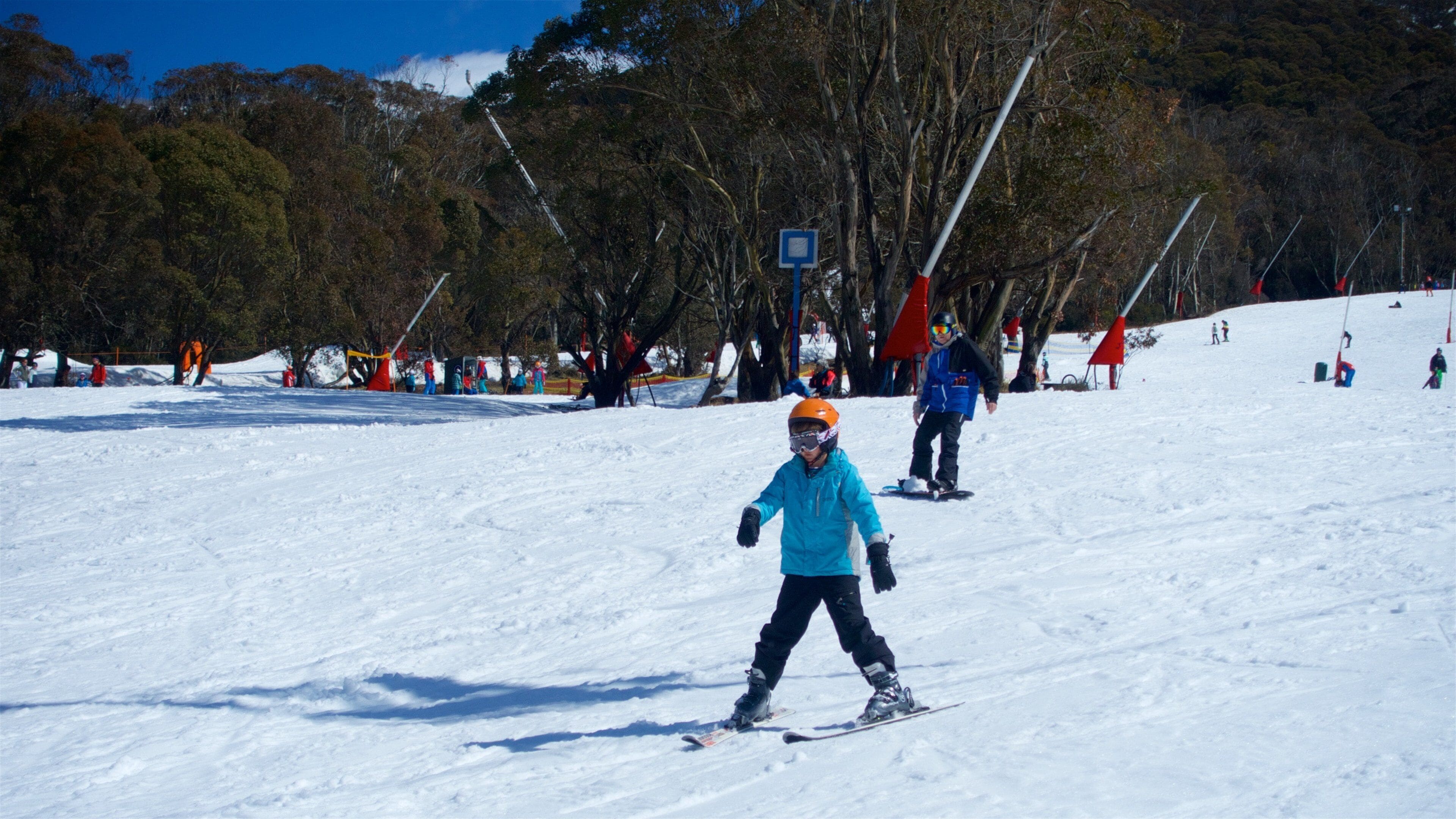 A snowy ski slope with skiers and snowboarders.