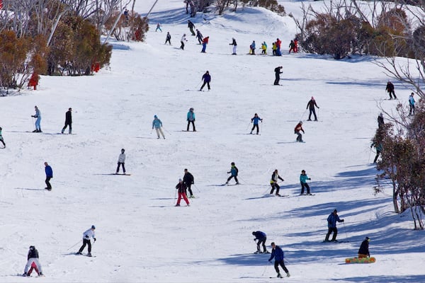 A snowy ski slope with skiers descending.