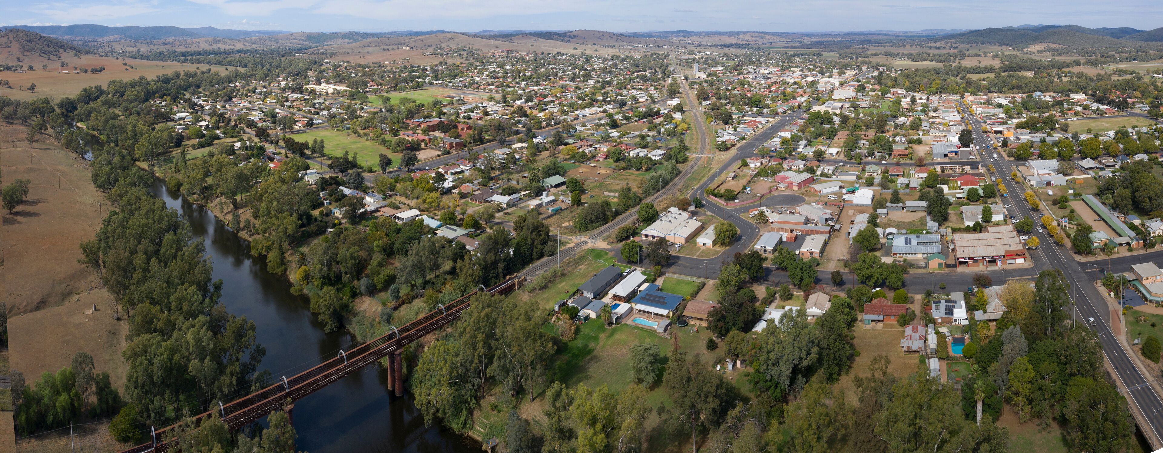 A town with a river, a bridge, and surrounding hills.