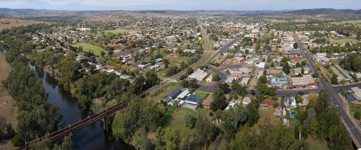 A town with a river, a bridge, and surrounding hills.