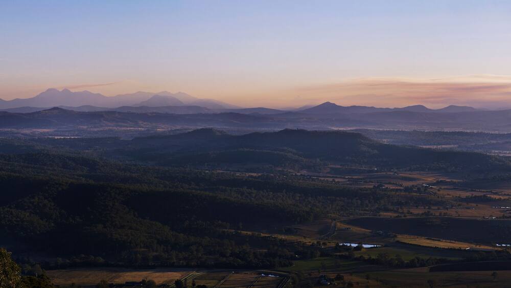 A mountainous landscape with rolling hills and scattered buildings.