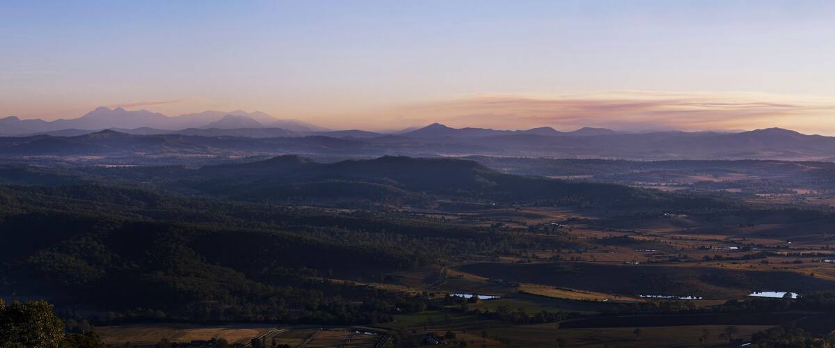 A mountainous landscape with rolling hills and scattered buildings.