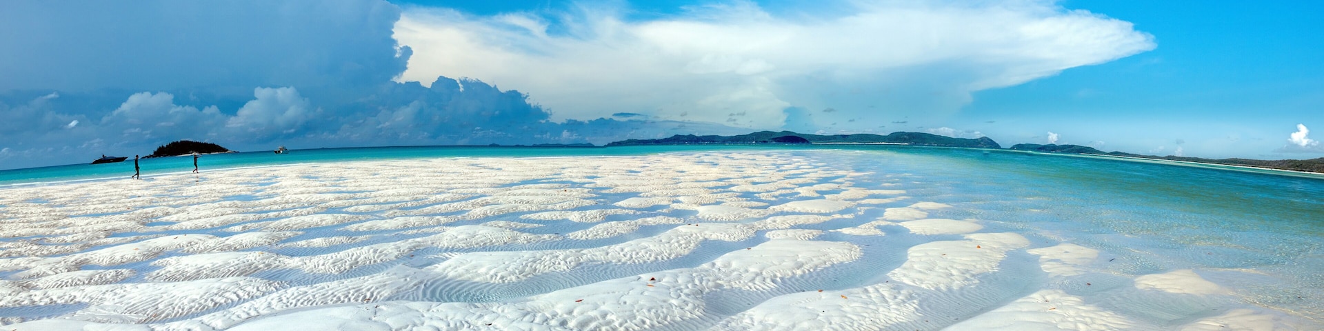 A beach with white sand and clear turquoise water.