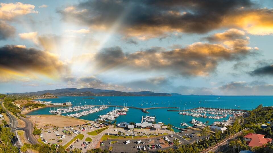 A marina with boats, a parking lot, and a coastal road.
