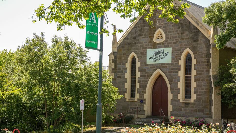 A stone building with a sign reading "Abbey Antiques and Vintage Store."