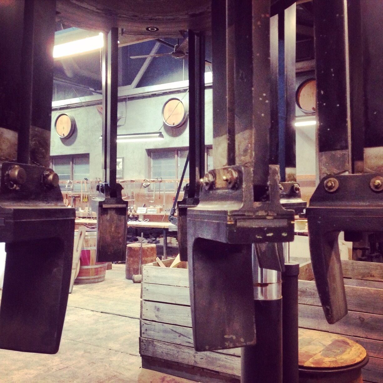 Maquinaria industrial en un taller con cajas de madera y estructuras metálicas.