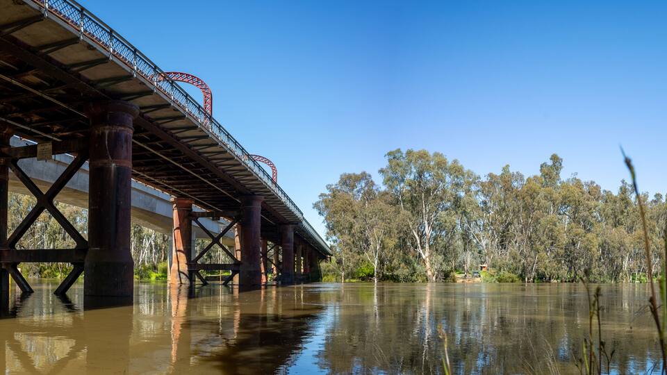 Panoramic view of historic Echuca-moama Road Rail Bridge over calm waters of the Murray River, between the twin towns of Echuca in Victoria and Moama in New South Wales and a heritage local landmark.
