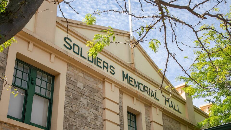 A building labeled "Soldiers Memorial Hall" with stone walls and green-framed windows.