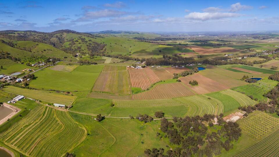 A rural landscape with rolling hills, agricultural fields, and a small village.