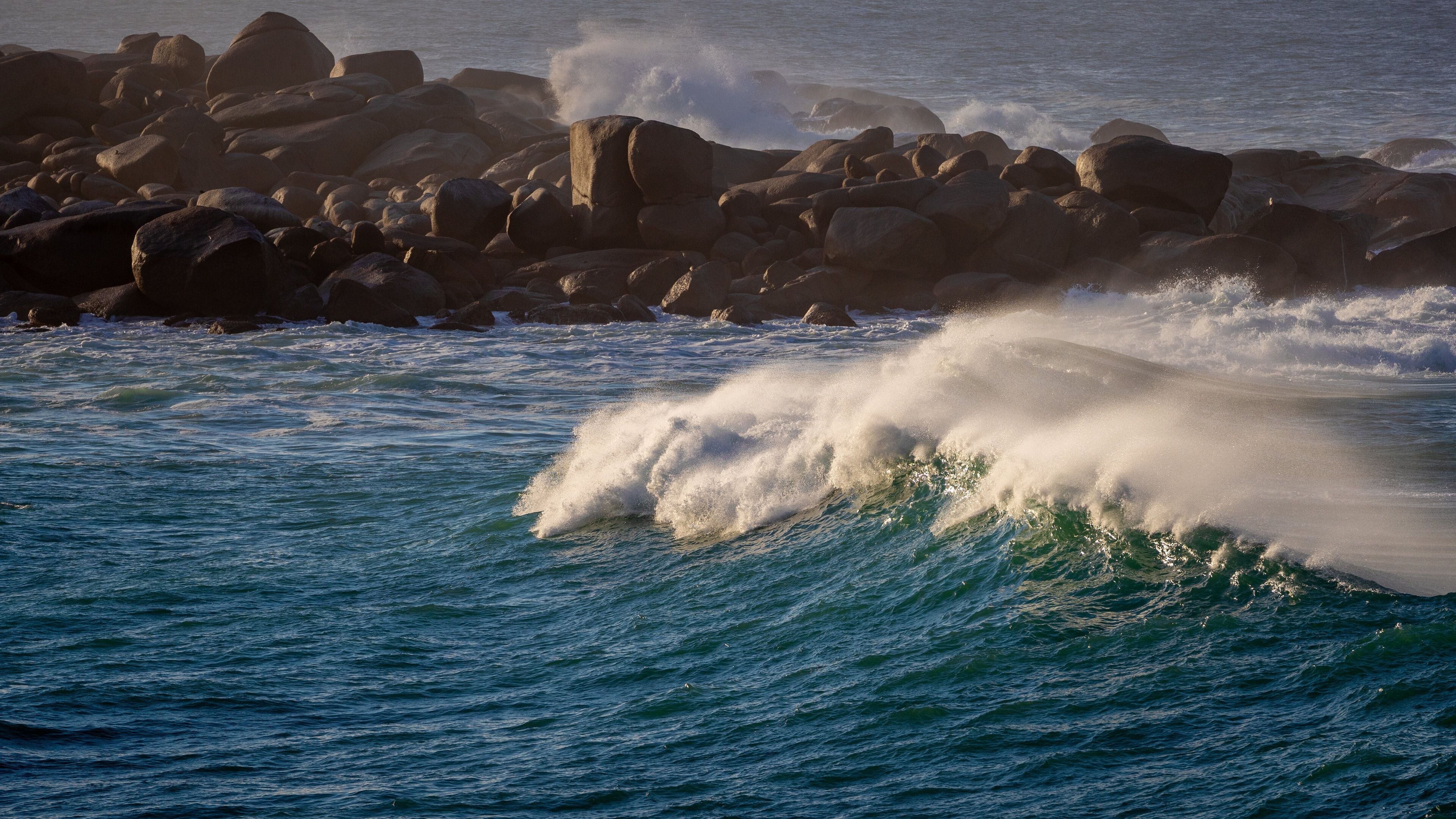 A rocky coastline with waves crashing against the rocks.