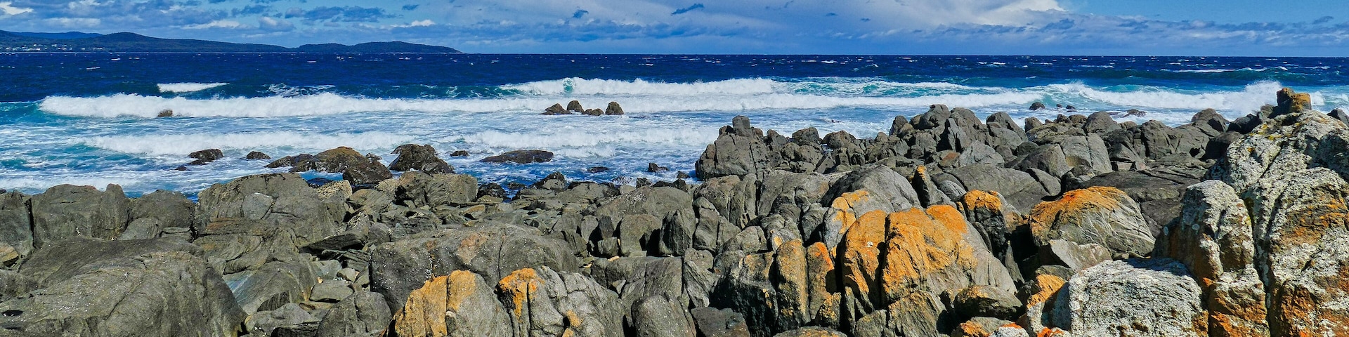 Panorama of a rugged rocky coast and breaking waves on a stormy day. Low Head, George Town, in the Launceston region of northern Tasmania, Australia.