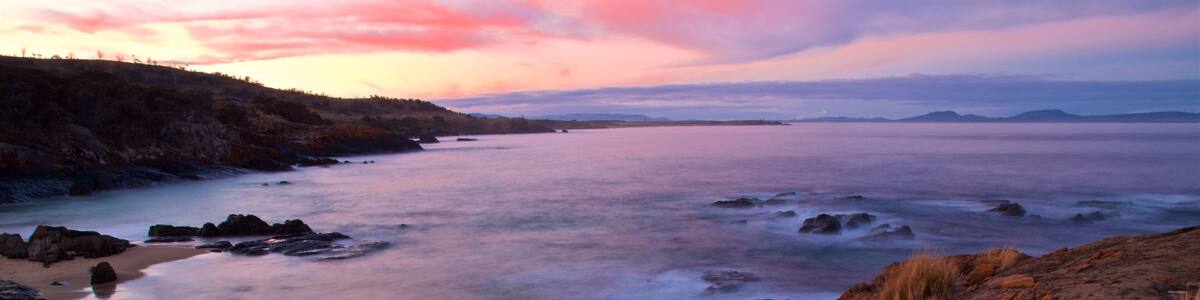 Swansea which includes rugged coastline, general coastal views and a sunset