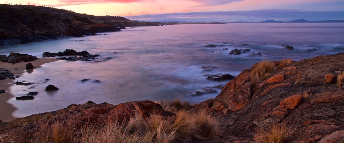 Swansea which includes rugged coastline, general coastal views and a sunset