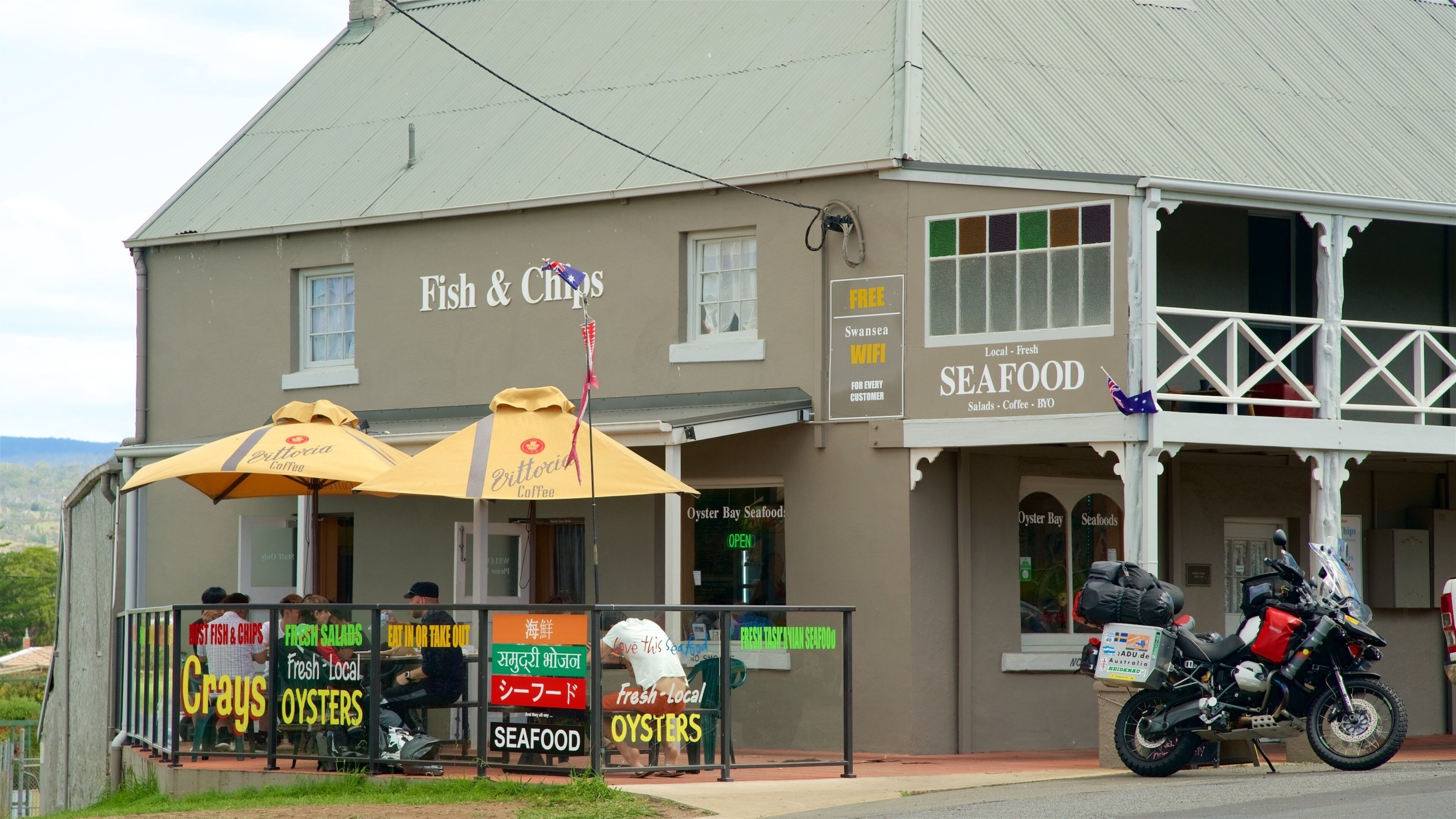 A seafood restaurant with outdoor seating and a motorcycle parked outside.