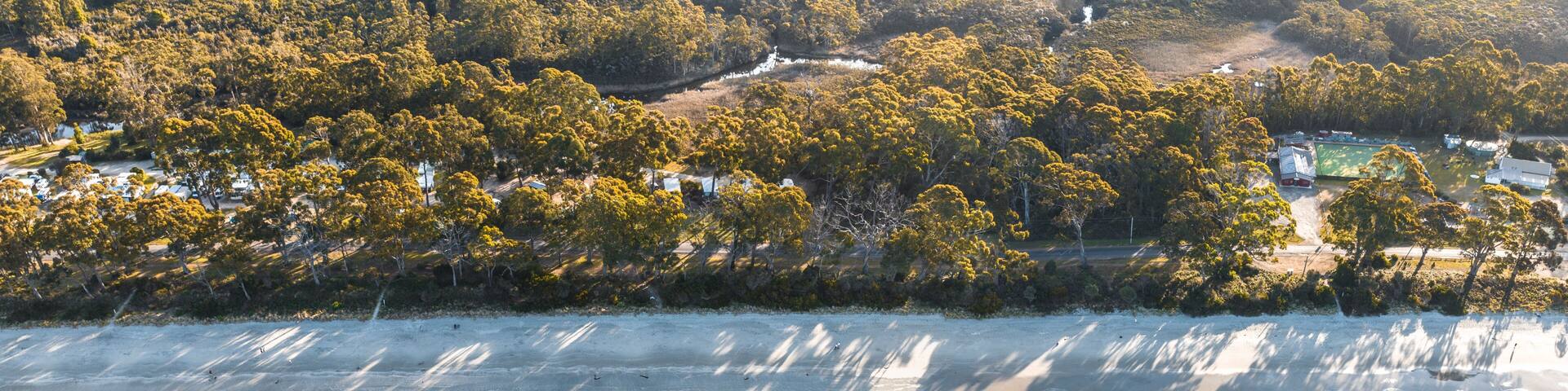 Drone Birdseye view of Adventure Bay, Tasmania, Australia. Blue water with shadows during sunset. Beautiful beach and travel concept.