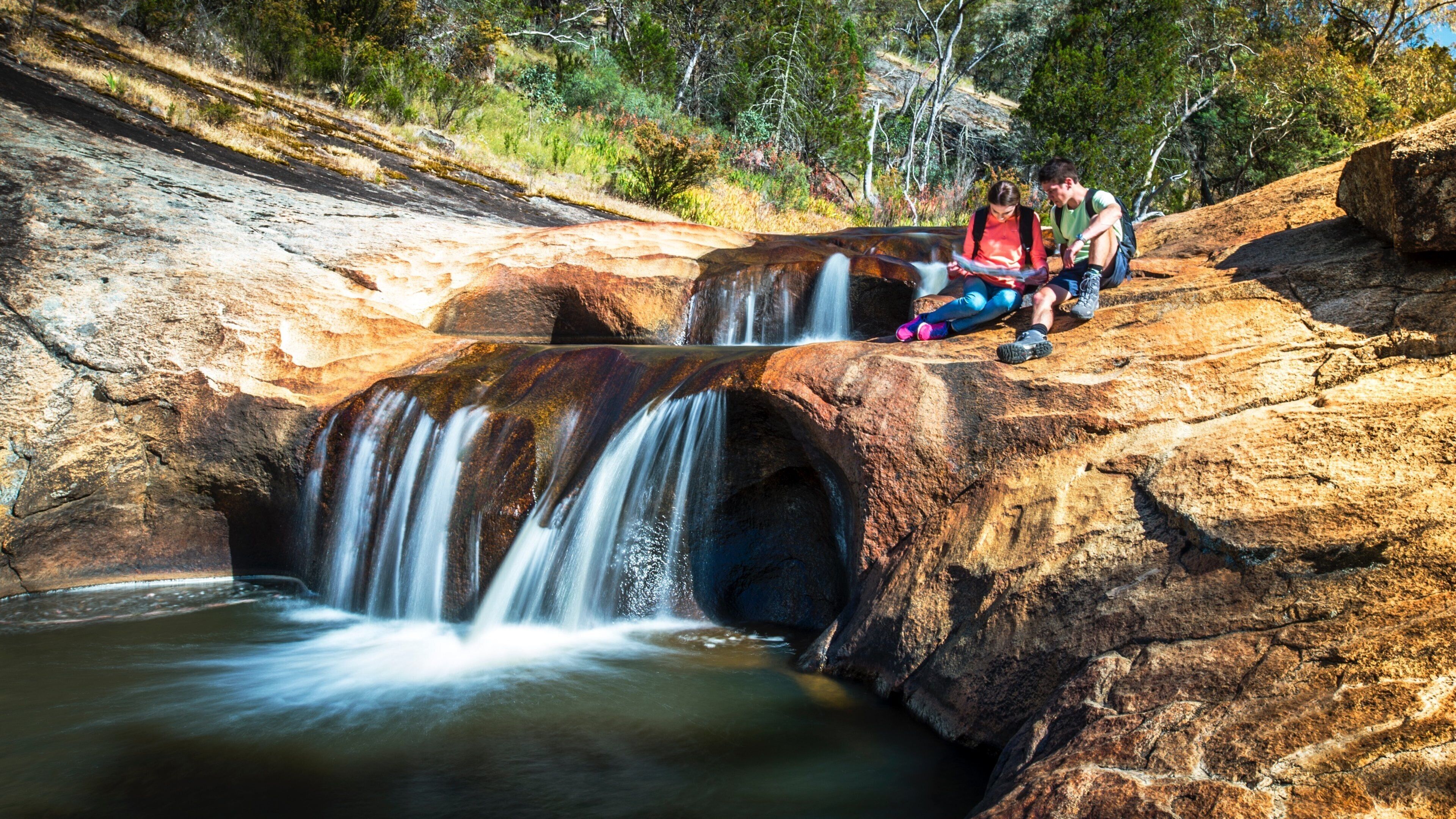 A waterfall cascading over a rocky outcrop surrounded by trees.