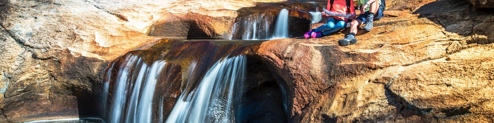 A waterfall cascading over a rocky outcrop surrounded by trees.