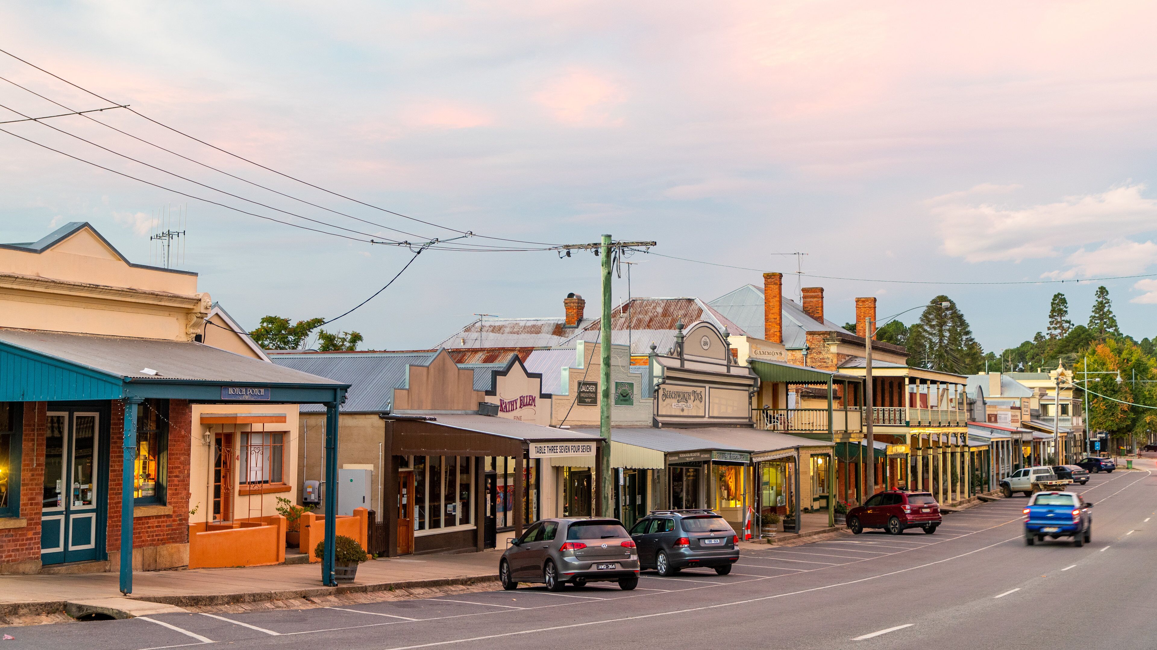 A street lined with historic buildings, including a pub named 'The Hitchhiker's Pub' and a restaurant called 'The Old Inn'.